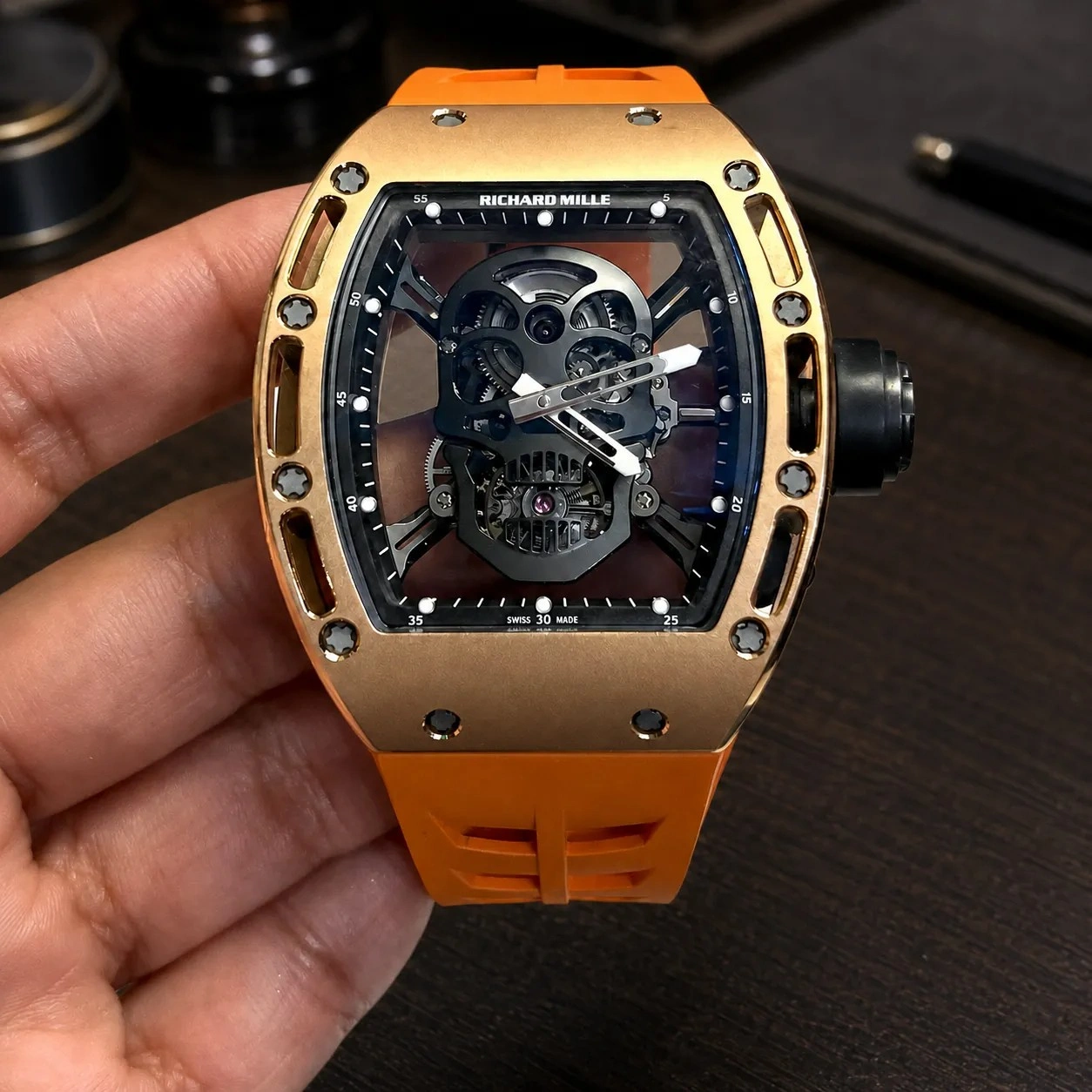 Customer showcasing the Richard Mille RM 052 Skull watch with an orange strap.
