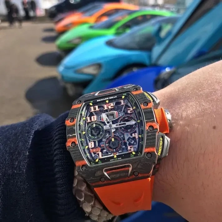 Customer wearing the Richard Mille RM 11-03 McLaren watch with an orange strap during everyday use.
